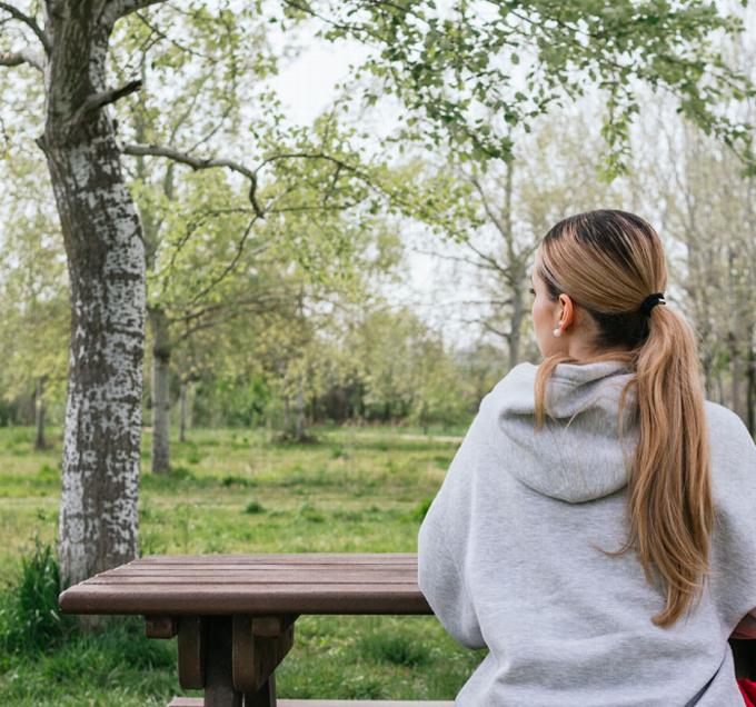 lady sitting at bench in park 